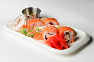 California or Philadelphia sushi rolls set served on a white tray over white background. Japanese cuisine concept