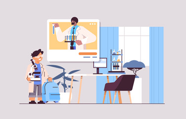 Fototapeta premium schoolboy making chemical experiment with teacher in web browser window during video call self isolation