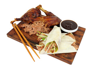 Aromatic half crispy duck with Chinese style pancakes and hoisin sauce on a wooden board isolated...
