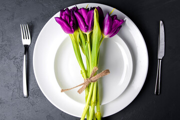 Spring table settings with fresh tulips and cutlery. Copy space banner.