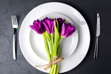 Spring table settings with fresh tulips and cutlery. Copy space banner.