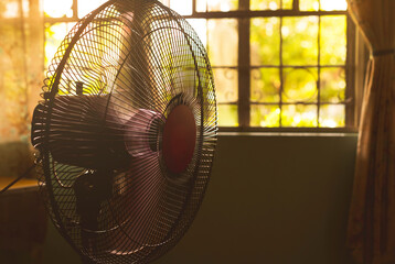 A running electric fan inside a room during a sweltering and hot day. Concept of heat wave or...