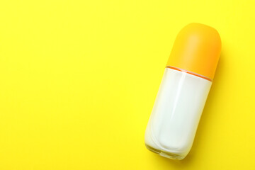 Blank roll-on deodorant on yellow background, space for text