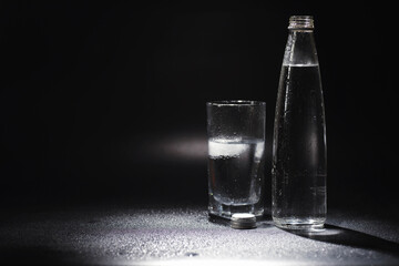 Close up pouring purified fresh drink water from the bottle on table in living room. Drinking water. Mineral vitamin water. Healthy, mineral-rich, refreshing water.