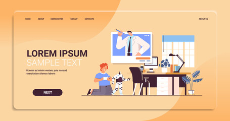 schoolboy playing with radio controlled robotic toy and discussing with teacher during video call self isolation