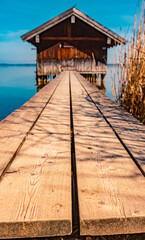 Beautiful alpine spring morning view with a perspective view of the entrance to a fisherman's hut at the famous Chiemsee, Chieming, Chiemgau, Bavaria, Germany