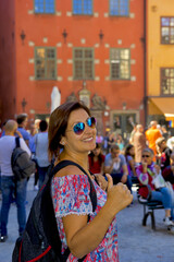happy young woman in sunglasses smiling at camera in stockholm, sweden