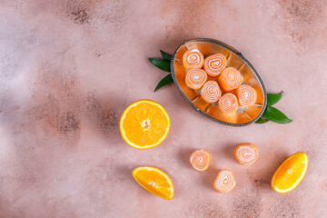 Orange color jelly rolls with orange fruits.