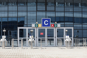 Glass doors and turnstiles, entrance to the indoor stadium arena, airport. No people or visitors. Terminal.