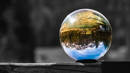 Crystal ball alpine landscape shot with black and white background outside the sphere at the famous Hintersee, Ramsau, Berchtesgaden, Bavaria, Germany