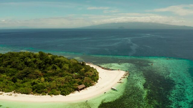 Sandy beach on tropical island surrounded by coral reef, top view. Mantigue island. Small island with sandy beach. Summer and travel vacation concept, Camiguin, Philippines, Mindanao
