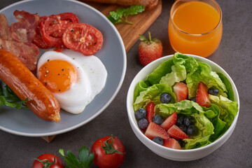 Delicious breakfast with fresh croissants, fried eggs with bacon and coffee served, orange juice. strawberry, butterhead, blackberry salad. full american breakfast top view.
