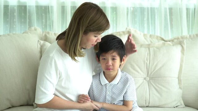 Asian Mother Embracing And Consoling Her Son