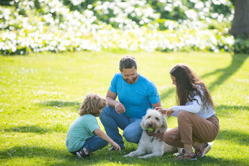 Family relaxing in garden with pet dog. The concept of a happy family. Parents and children on vacation playing together outdoor.