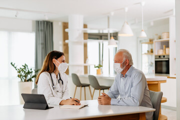 Young doctor giving advice to her mature patient, at private clinic.