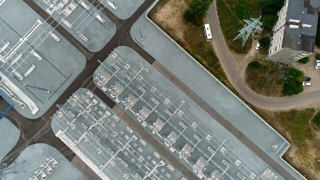 Rows of power transmission lines and transformers at huge electrical distribution substation on summer day upper view