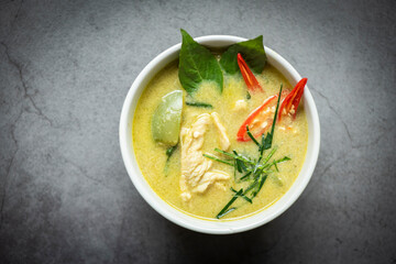 Chicken green curry Thai food on soup bowl with ingredient vegetable herbs and spices pepper chili dark background, Traditional green curry chicken cuisine asian food. Top view