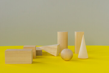 wooden geometric shapes on a yellow background. preschool learning