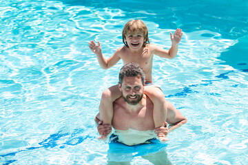 Dad carry on shoulders funny child boy in swimming pool. Father and son weekend.