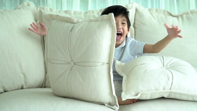 Cute Asian Child Playing Hide And Seek On Sofa2