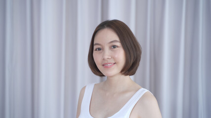 Fototapeta na wymiar portrait of asian woman short hair in white smiling confidence face expression on background. attractive beautiful female 30's dark brown hair posing for fashion. confident and thinking act.