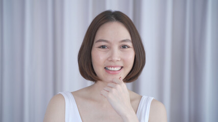 portrait of asian woman short hair in white smiling confidence face expression on background. attractive beautiful female 30's dark brown hair posing for fashion. confident and thinking act.