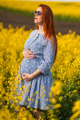 Naklejka na ściany i meble Pregnant woman on the summer field