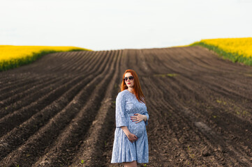 Pregnant woman on the summer field