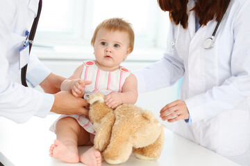 Happy smiling girl-child at usual medical inspection. Doctor and female toddler patient in the clinic. Medicine concept