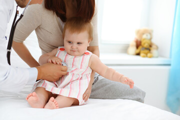 Happy smiling girl-child at usual medical inspection. Doctor and female toddler patient in the clinic. Medicine concept