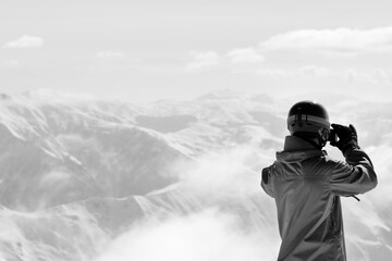 Snowboarder makes photo on camera. Black and white toned image.