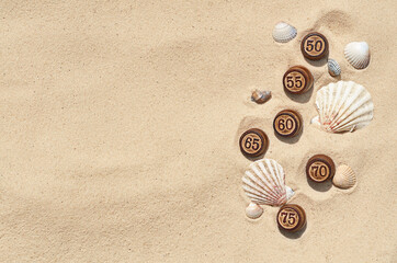 Fototapeta na wymiar barrels with numbers on the sand with shells for the summer sale