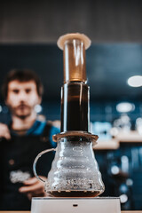 Pressurized coffee brewing using an aeropress - the barista presses the piston