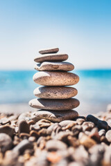 Stack of smooth pebble stones on the seashore - holiday season
