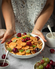 cereal pancackes with cherries and yogurt, berries, breakfast with woman hand