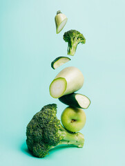 Cut broccoli and zucchini with green apple isolated on a light blue background. Fresh and healthy...