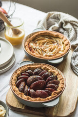 Plum and apple tart on the kitchen on the table with linen tablecloth, summer tart