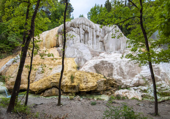 Fototapeta na wymiar Bagni San Filippo (Italy) - In Tuscany region on Monte Amiata, it's a public and wild small hot waterfall with white stone deposits named Balena Bianca.