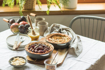 Plum and apple tart on the kitchen on the table with linen tablecloth, summer tart
