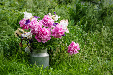 Bouquet of bright pink peonies against the background of a green spring garden