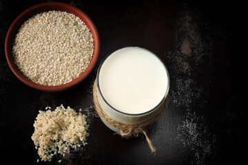 Sesame milk in a glass. A bowl of sesame seeds. Vegan milk. Healthy drinks.