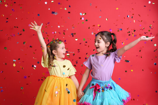 Adorable Little Children And Falling Confetti On Red Background