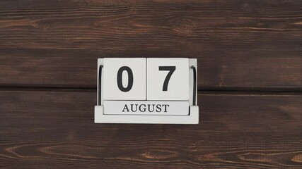 august calendar, change of days. calendar with date month and day on a wooden table. fast pace of time during the month. accelerated daily log. Time passes quickly. holidays in august . Stop motion