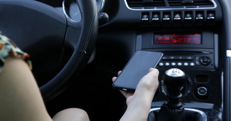 Woman is pairing her phone with car music system via bluetooth - obrazy, fototapety, plakaty