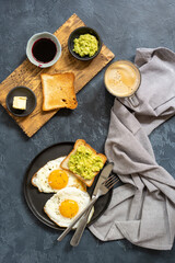 Fried eggs with toast, avocado, jam and coffee mug. Breakfast concept. Top view, flat lay. Tasty breakfast. Typical hotel breakfast. 