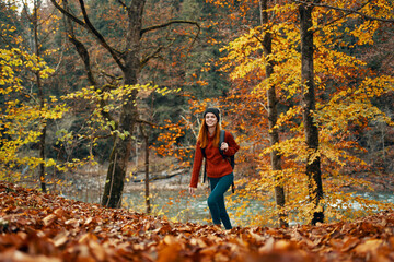woman travels in autumn forest in nature landscape yellow leaves on trees tourism river lake
