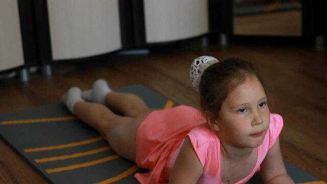Girl gymnast is engaged at home on a sports mat. Fitness concept and sport lifestyle