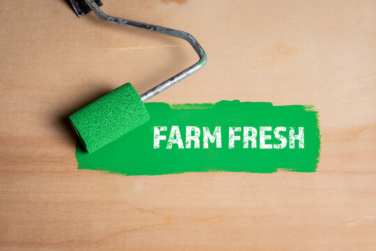 Farm Fresh. Paint roller with green paint on a wooden surface