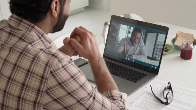 Indian entrepreneur talks to male black man potential employee hiring for job using laptop. Virtual video call between employer entrepreneur and manager worker. Remote recruitment work concept.