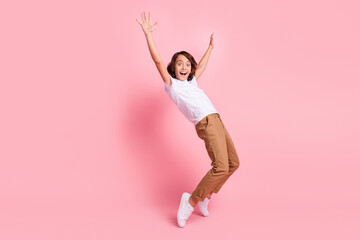 Full size photo of cheerful positive amazed little boy raise hands good mood isolated on pink color...